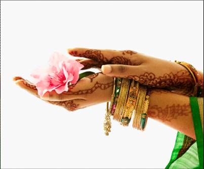 Folded hands of a South Asian woman with traditional henna and delicate gold bracelets on her arm . This photograph perhaps represents how traditional South Asian female roles are being embraced, especially in relation to marriage and weddings