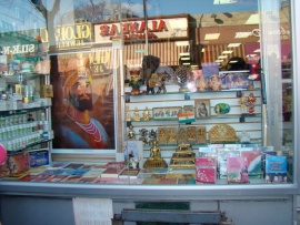A store selling many religious statues, just outside, not pictured, copies of the Qur'an were being sold.  This represents the cultural contact in Jackson Heights, how two religions that are very different in beliefs can be featured so close to one another.