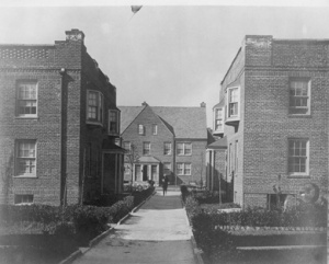 Street view of Sunnyside Gardens from the past. Note the shared central courtyard and walkway. This image is from Sunnyside Chamber