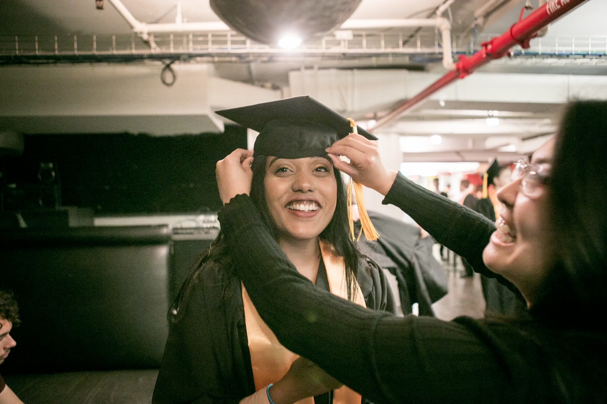 Student in robe. Macaulay Commencement. Photo by Arpi Pap