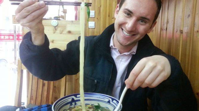 Macaulay student with noodles in restaurant during study abroad trip to China